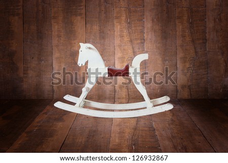 Child\'s wooden rocking horse, in the background of the wood.