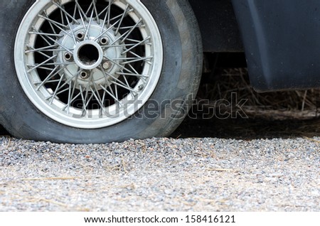 Close up of a flat tire, old classic cars.
