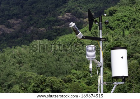 Wind speed measurement devices Against a backdrop of green trees on the mountain.