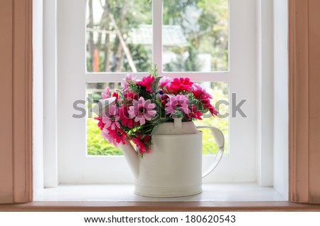 Bouquet of artificial flowers in a window to look through the window relaxation concept