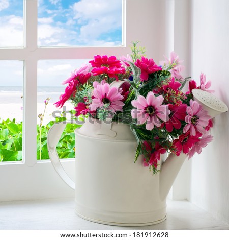 Bouquet of artificial flowers in a window to look through the window at the sea. relaxation concept