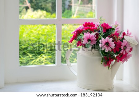 Bouquet of artificial flowers in a window to look through the window, relaxation concept.