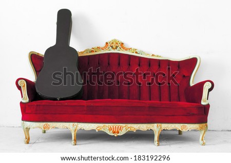 Box guitar on vintage luxury armchair isolated on white background with clipping path.