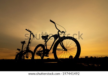 Silhouette stationary bike at sunset sky beautifully.