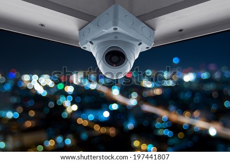 The security cameras on a balcony high building. City view at night with blurred light
