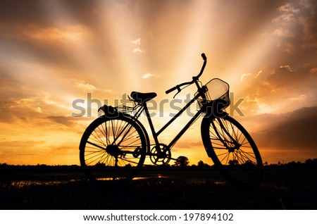 Silhouette stationary bike at sunset sky beautifully.