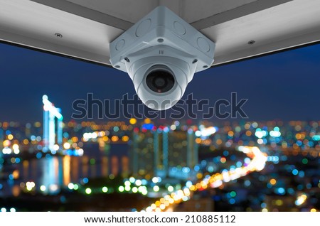The security cameras on a balcony high building, Cityscape view with blurred lights.