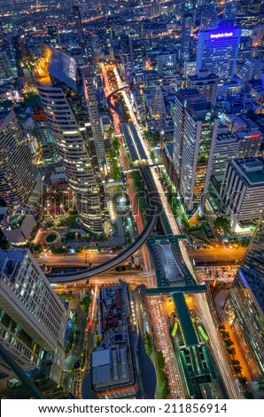 Birds eye view of a modern building at night. Traffic in the business district The Skytrain station Chong Nonsi