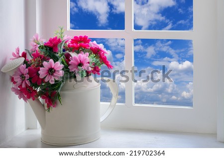 Bouquet of artificial flowers in a window to look through the window at the sky. relaxation concept