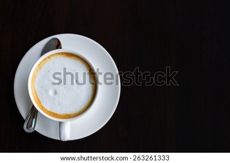 Top view of a cup of coffee, cappuccino on a wooden table.