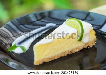 Lemon cheese cake on a black plate.