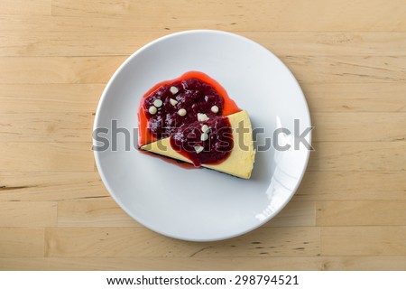 White chocolate cheesecake topped with strawberry cream berries on a white plate, Top view.