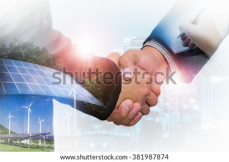 Double Exposure of a businessman handshake on the background blurred downtown nightlife. Concept of an agreement green energy.