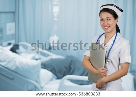 Asian nurse holding notebook with background blur patient room.