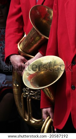 close up of musicians in red suit with theirs saxhorns