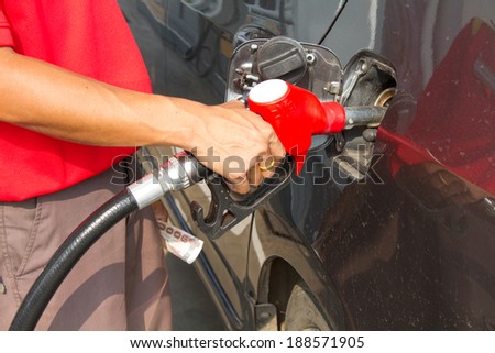 Hand refilling the car with fuel at Petrol pump filling