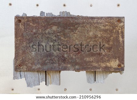 Old metal plate on metallic wall