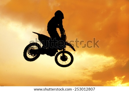 silhouette of biker jumping on motorbike on sunset / Extreme sports background