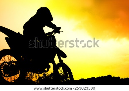 silhouette of biker jumping on motorbike on sunset / Extreme sports background