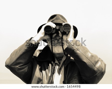 Man looking with binoculars. Older explorer watching nature with binoculars