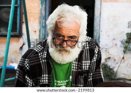 Old man portrait. Old man wearing glasses and grey beard.