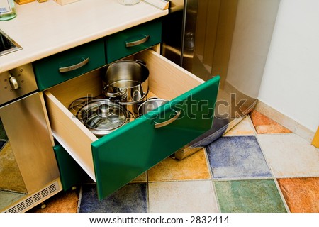 Open kitchen cupboard with dishes for cooking. Colorful kitchen interior