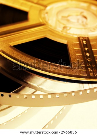 Film reel on yellow light. Movie entertainment concept - Stock