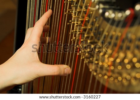 Harp and hand on strings. Classic music concept