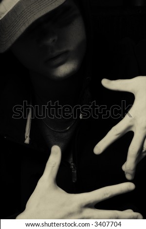 Man in hood and hat. Dark portrait of hip hop and rap music singer