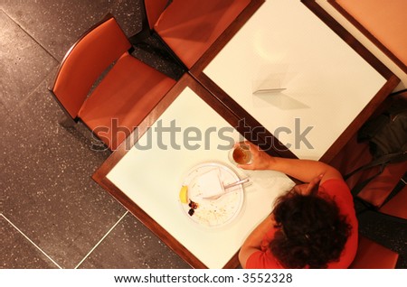 Lone woman waiting in fast food restaurant.