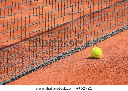 Detail of clay tennis court. Tennis ball and net detail