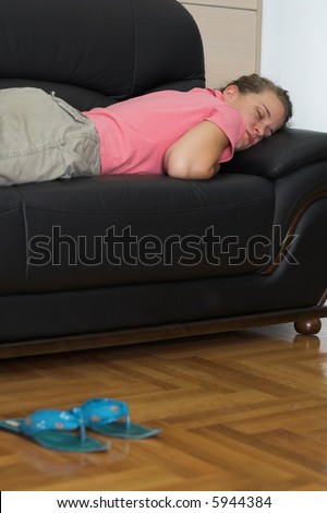 Young woman taking a nap on a couch. Day sleep concept