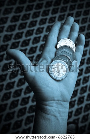 One euro coin money in hands on blue light. Business and economy concept