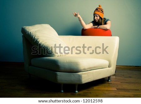 Cute young woman calling you on the sofa.  Lounge and relaxation concept