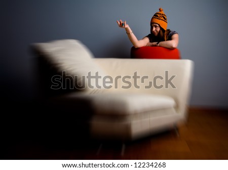 Cute young woman calling you on the sofa. Lounge and relaxation concept. Zoom blur effect