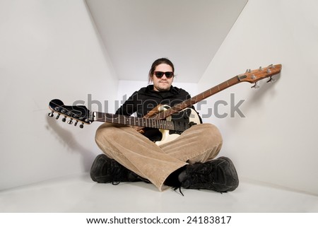 young man with guitar and bass in white tunnel space. Rock music concept