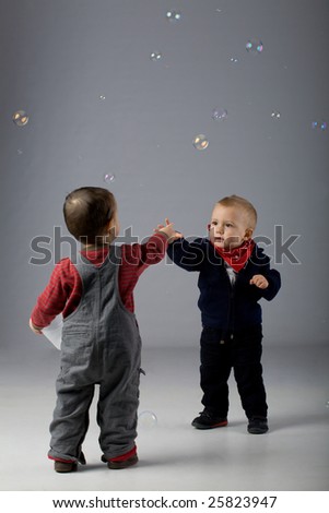 Cute toddlers meet. Two young baby friends with bubbles
