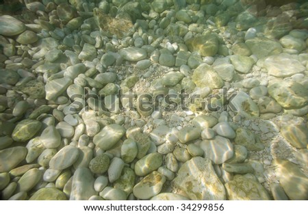 Pebble stones underwater on a sea bed. Marine background