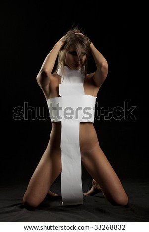 stock photo Sexy naked girl with paper clothes covering her in the cross 