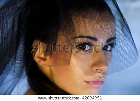 Young beautiful woman face expression  under the black veil