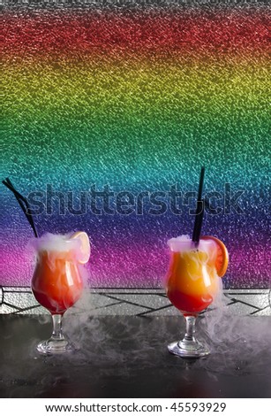 Alcoholic cocktails with dry ice smoke in front of broken glass background