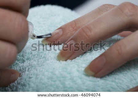Manicurist applying beauty nail polish