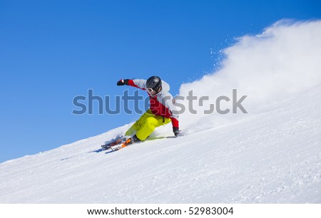Aggressive sport skier in the snow powder skiing fast