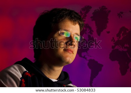 Young pensive man in front of purple world map wall. Future vision concept