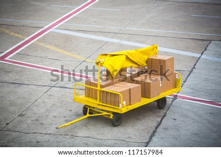 Airport vehicle transporting air cargo  to airplane on runway