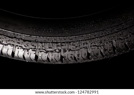 Isolated winter tire with water drops. Aquaplaning concept of traffic safety