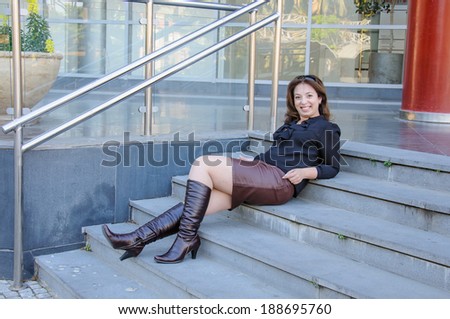 Smiling businesswoman lying on stairs of office building outside