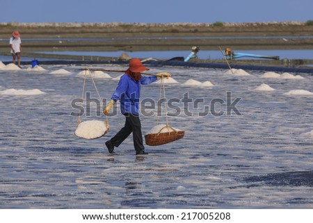 A salt farmer working in salt field in samutsakorn, thailand