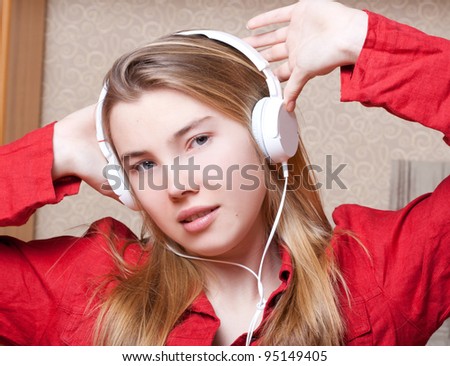 Girl listening to music or a girl in a red shirt and white earphones