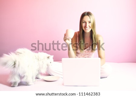 Beautiful young woman with persian cat, coffee and laptop at home